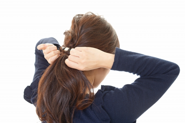 髪を束ねる女性の画像
